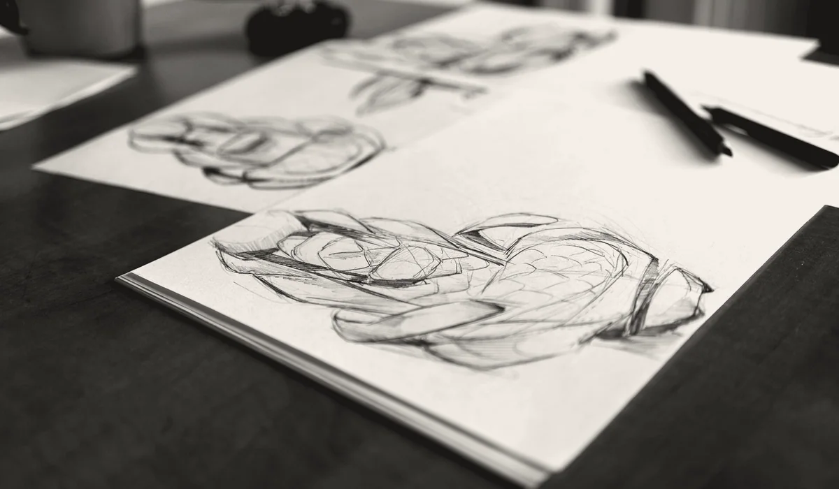An artist portfolio and sketchbook open on a table.