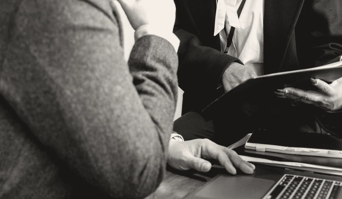 Two people going through documents in an office.