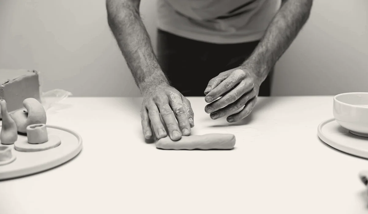 An artist's hands at work in a studio.