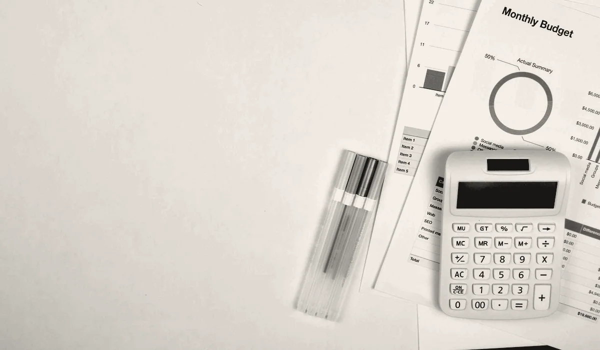 A budget spreadsheet and a calculator on a desk.