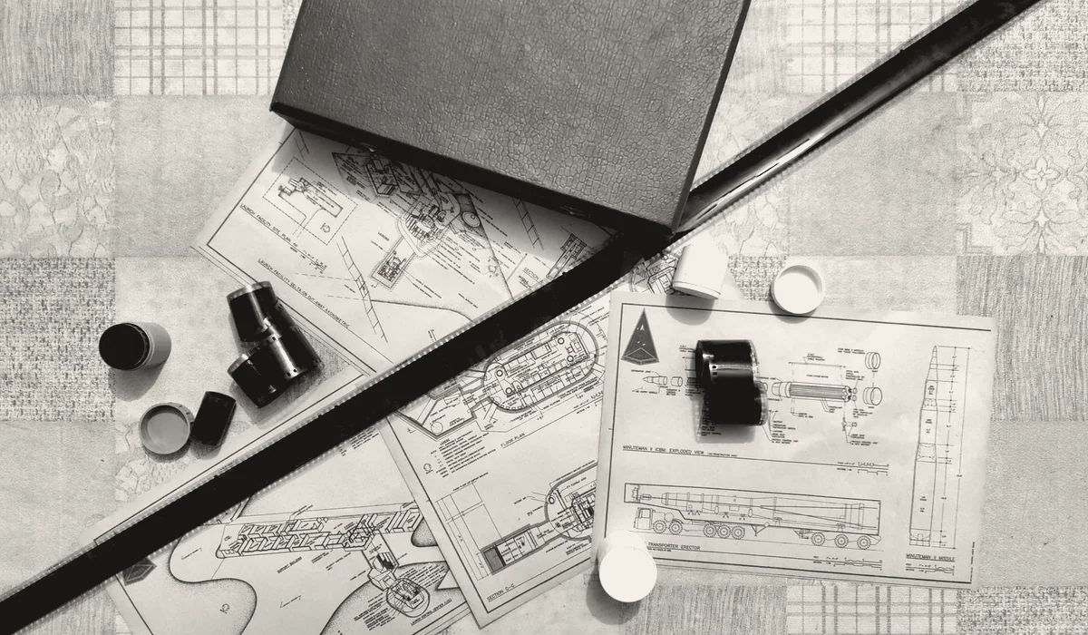 Rolled drawings and a set of plans laid out on a table.