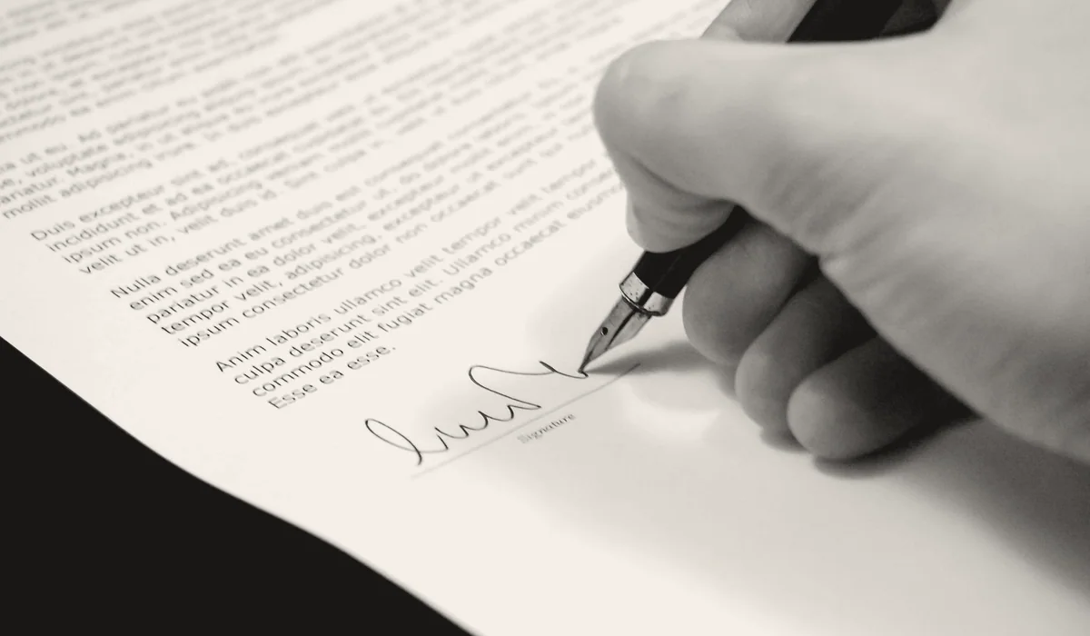 A pen resting on a signed contract.