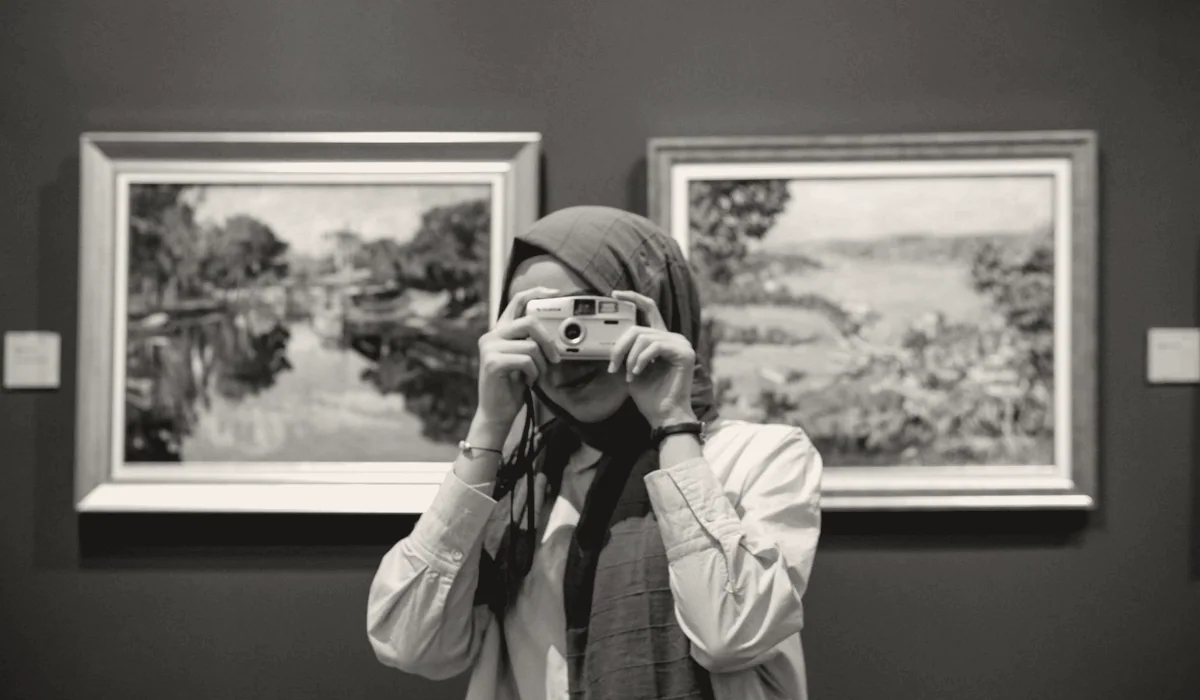 A photographer taking a picture of an artwork.