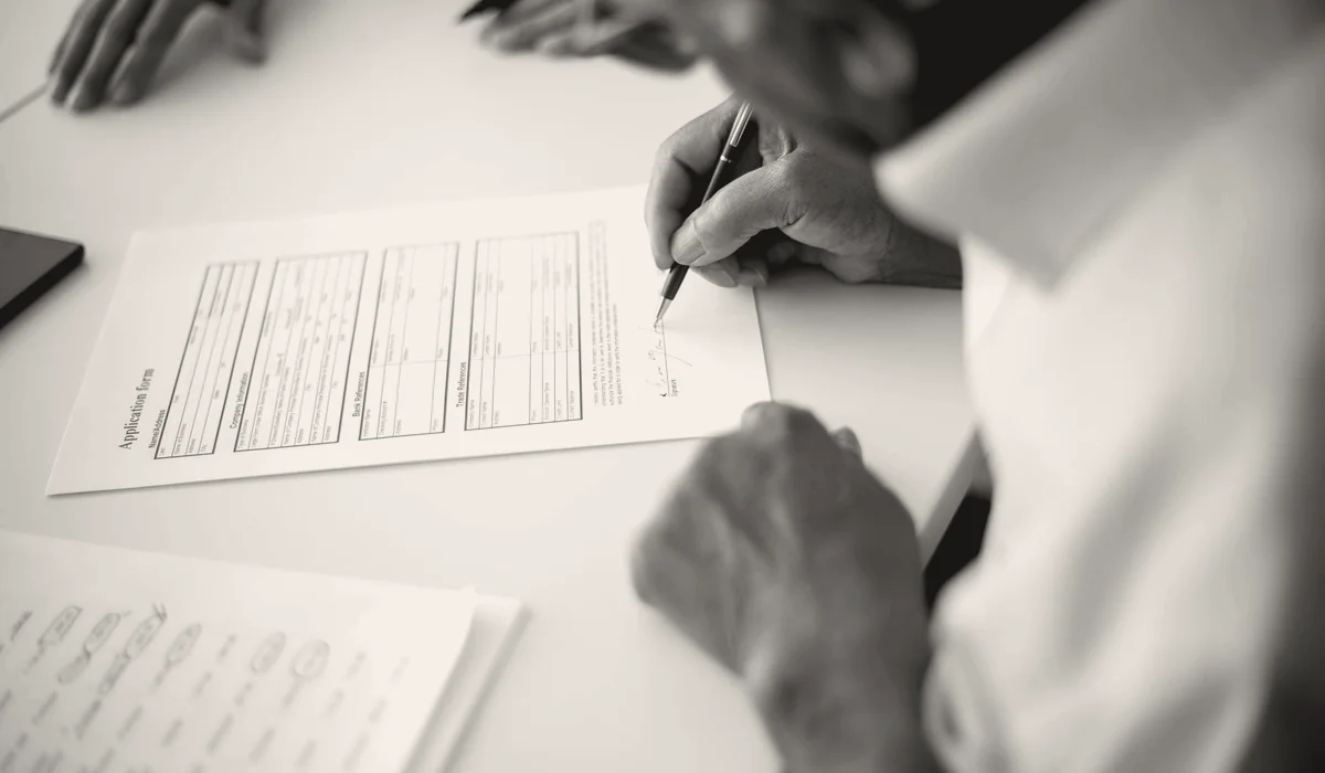An application form and paperwork on a desk.