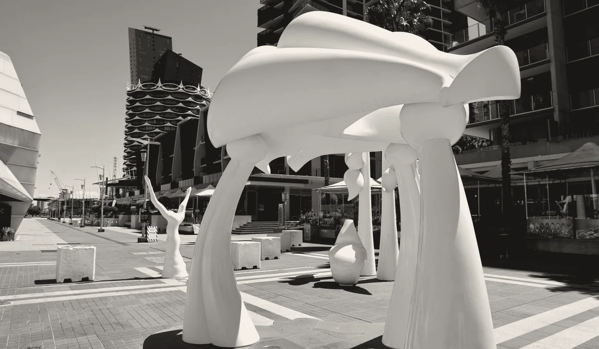A modern sculpture standing in a city square.