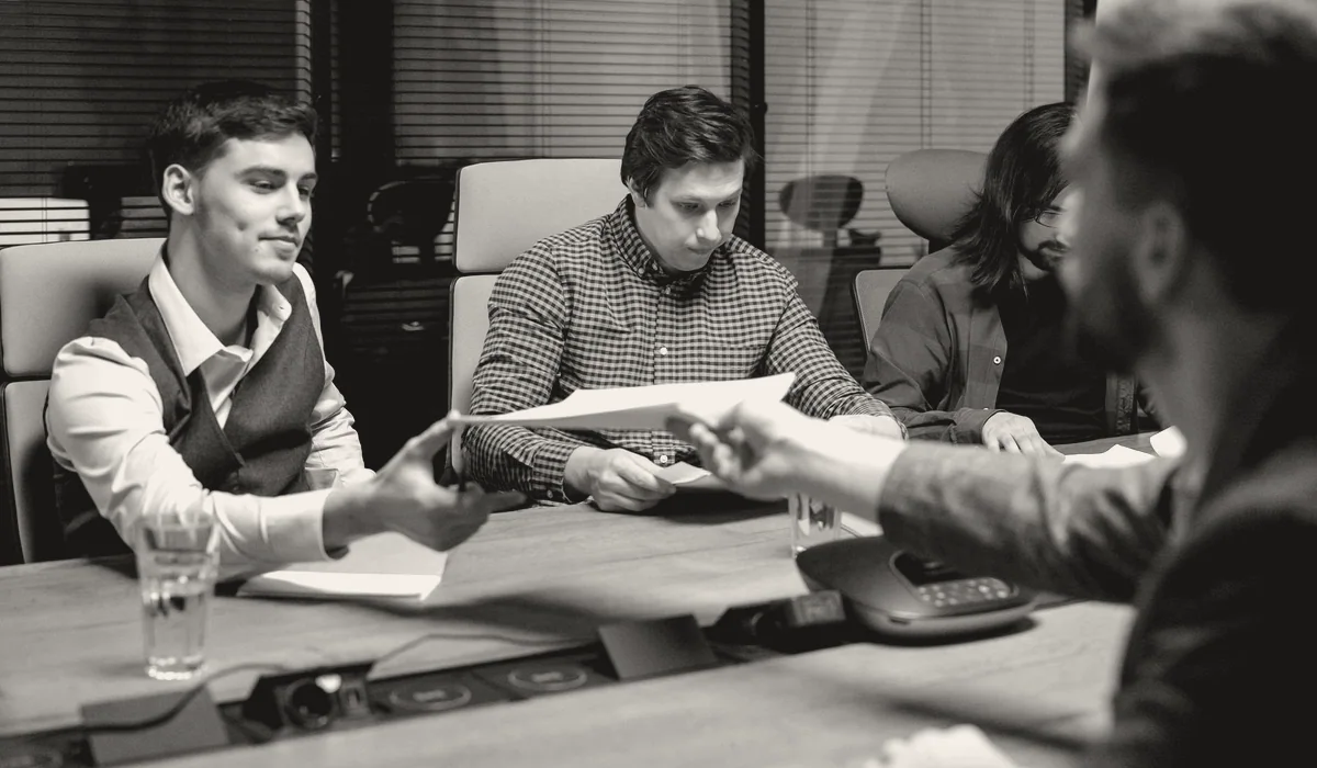 A panel of people reviewing material around a table.