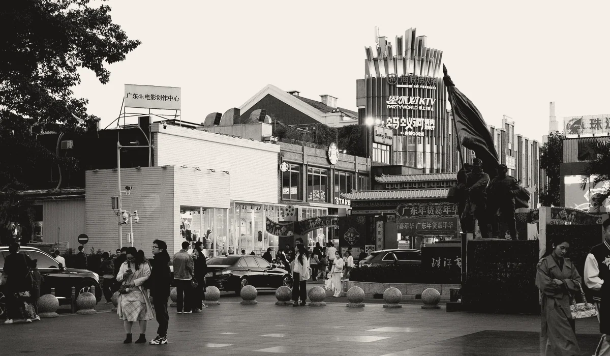 People gathered in a plaza around an artwork.